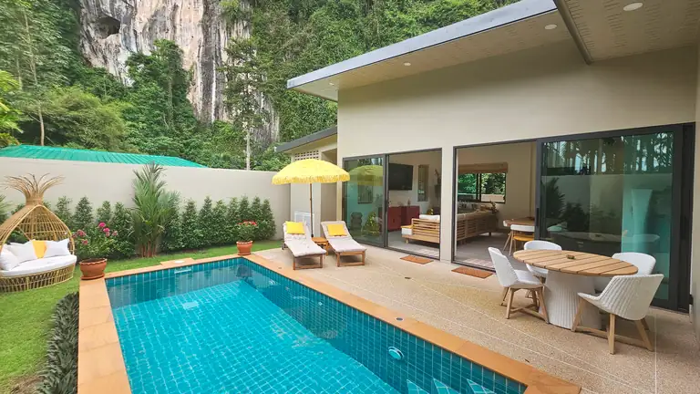 The back garden, swimming pool and rear elevation of a Cliff Villa The swimming pool and grounds of a pool villa in Krabi, with views to a cliff