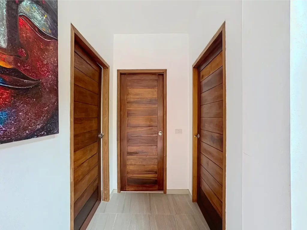 Hallway of a Krabi Cliff Villa 2 bedroom villa with three solid hardwood doors leading to bedrooms and bathroom