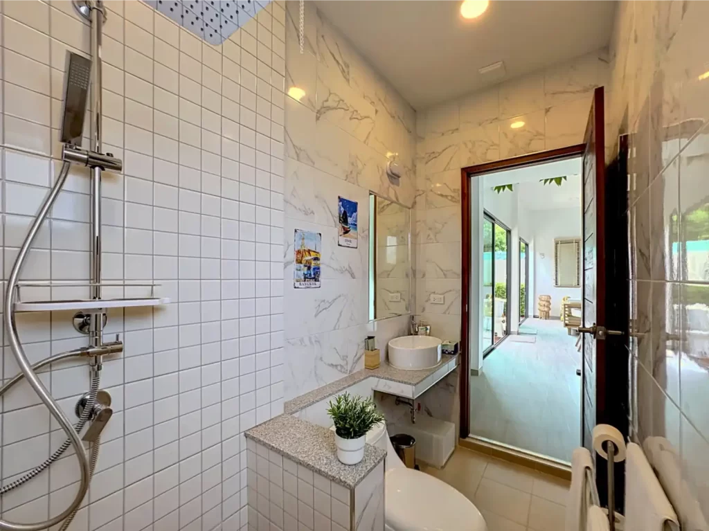 Main bathroom in a Krabi Cliff Villa 2 bedroom villa featuring rainfall shower, marble effect tiles and basin