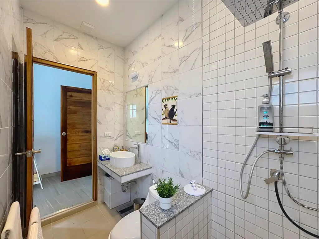En-suite bathroom of a Krabi Cliff Villa 2 bedroom villa showing rainfall shower with handheld fitting, vessel basin, granite vanity, and marble effect tiling