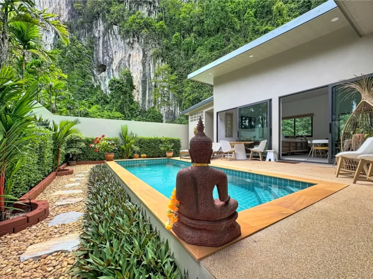 Private pool and tropical garden of a Krabi Cliff Villa 2 bedroom villa with Buddha statue, timber deck, sun terrace, and dramatic limestone cliff backdrop